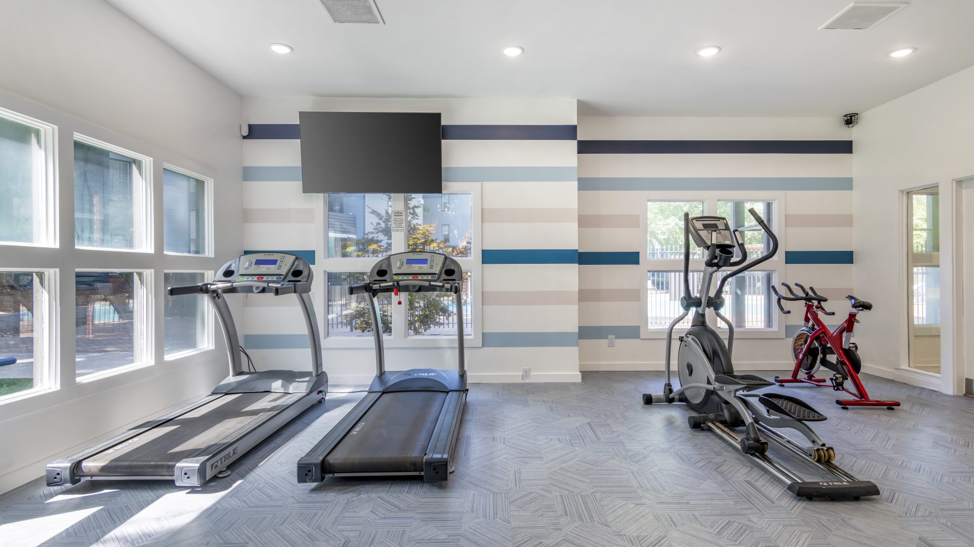 a gym room with treadmills and exercise equipment at The  Jaxon